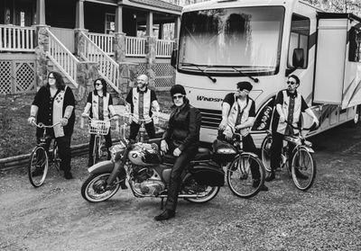Elvis and the Outlaws hanging out on their bikes in black and white
